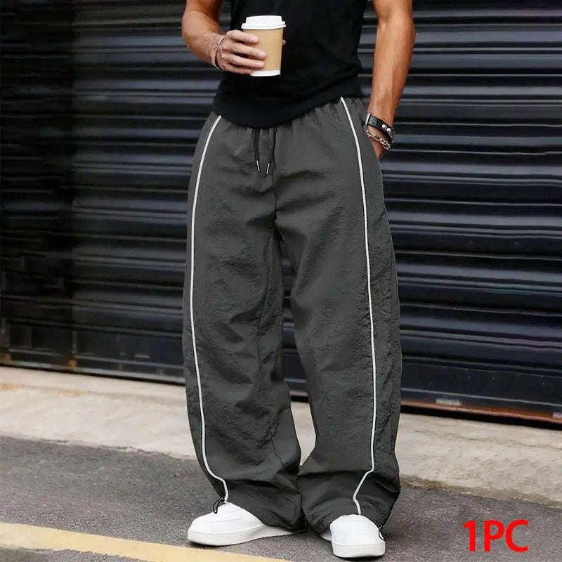 Men’s summer black-and-red quick-dry wide-leg pants with side stripes and a drawstring waist; breathable fabric with a slight wrinkle texture, loose straight cut, side stripe detailing, adjustable cuffs at the leg openings. Suitable for jogging, fitness,