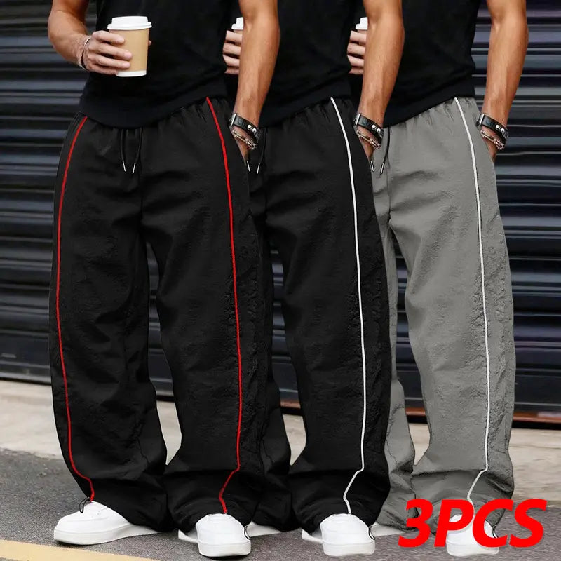 Men’s summer black-and-red quick-dry wide-leg pants with side stripes and a drawstring waist; breathable fabric with a slight wrinkle texture, loose straight cut, side stripe detailing, adjustable cuffs at the leg openings. Suitable for jogging, fitness,