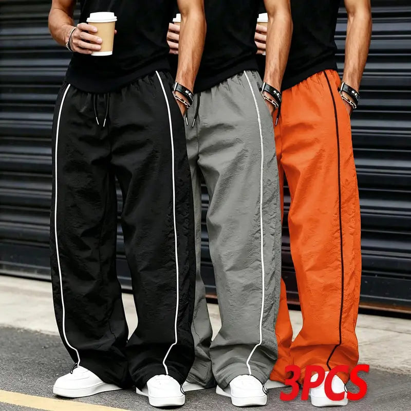 Men’s summer black-and-red quick-dry wide-leg pants with side stripes and a drawstring waist; breathable fabric with a slight wrinkle texture, loose straight cut, side stripe detailing, adjustable cuffs at the leg openings. Suitable for jogging, fitness,