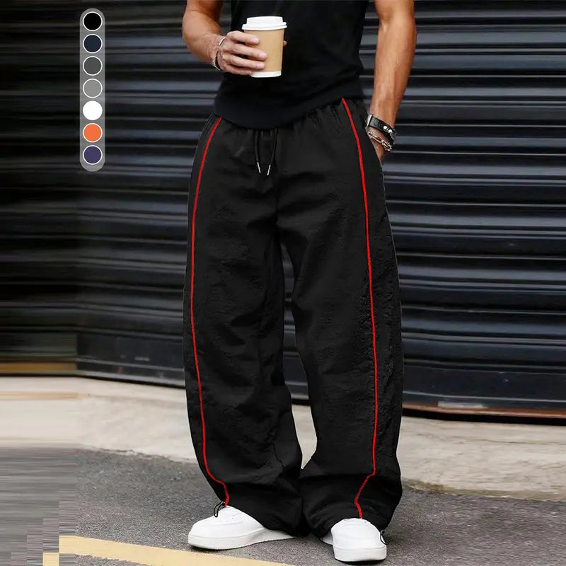 Men’s summer black-and-red quick-dry wide-leg pants with side stripes and a drawstring waist; breathable fabric with a slight wrinkle texture, loose straight cut, side stripe detailing, adjustable cuffs at the leg openings. Suitable for jogging, fitness,