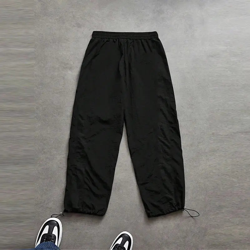 Men’s summer black-and-red quick-dry wide-leg pants with side stripes and a drawstring waist; breathable fabric with a slight wrinkle texture, loose straight cut, side stripe detailing, adjustable cuffs at the leg openings. Suitable for jogging, fitness,