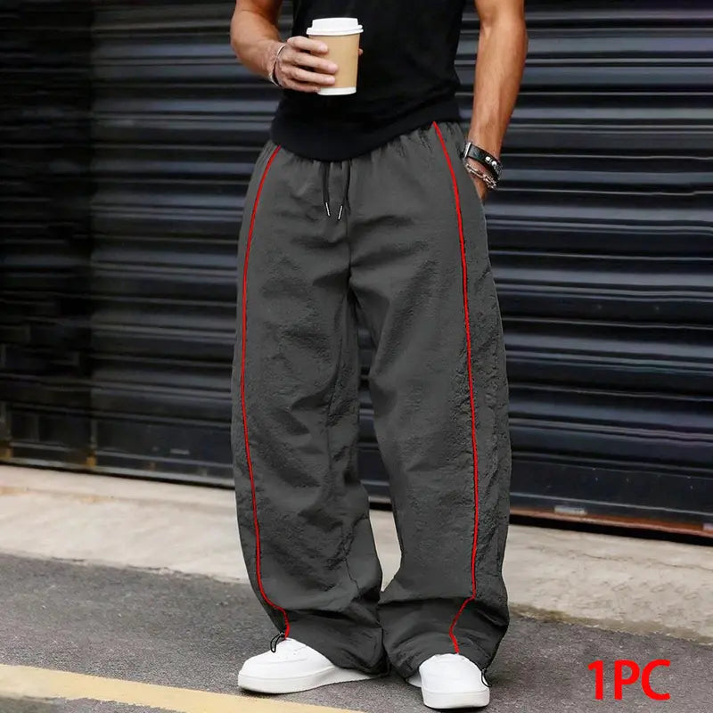 Men’s summer black-and-red quick-dry wide-leg pants with side stripes and a drawstring waist; breathable fabric with a slight wrinkle texture, loose straight cut, side stripe detailing, adjustable cuffs at the leg openings. Suitable for jogging, fitness,