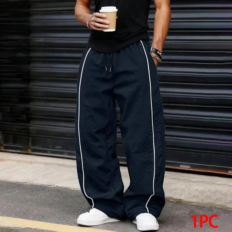 Men’s summer black-and-red quick-dry wide-leg pants with side stripes and a drawstring waist; breathable fabric with a slight wrinkle texture, loose straight cut, side stripe detailing, adjustable cuffs at the leg openings. Suitable for jogging, fitness,