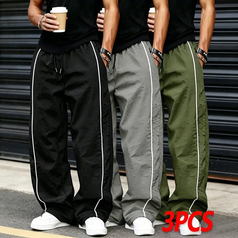 Men’s summer black-and-red quick-dry wide-leg pants with side stripes and a drawstring waist; breathable fabric with a slight wrinkle texture, loose straight cut, side stripe detailing, adjustable cuffs at the leg openings. Suitable for jogging, fitness,