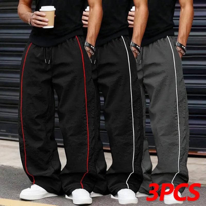 Men’s summer black-and-red quick-dry wide-leg pants with side stripes and a drawstring waist; breathable fabric with a slight wrinkle texture, loose straight cut, side stripe detailing, adjustable cuffs at the leg openings. Suitable for jogging, fitness,