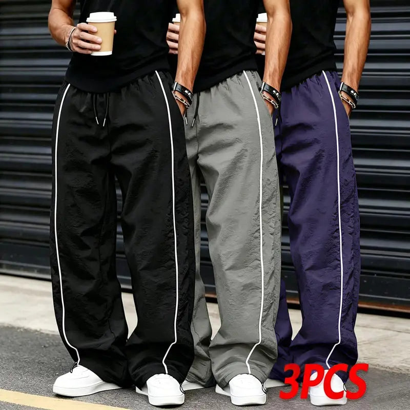 Men’s summer black-and-red quick-dry wide-leg pants with side stripes and a drawstring waist; breathable fabric with a slight wrinkle texture, loose straight cut, side stripe detailing, adjustable cuffs at the leg openings. Suitable for jogging, fitness,