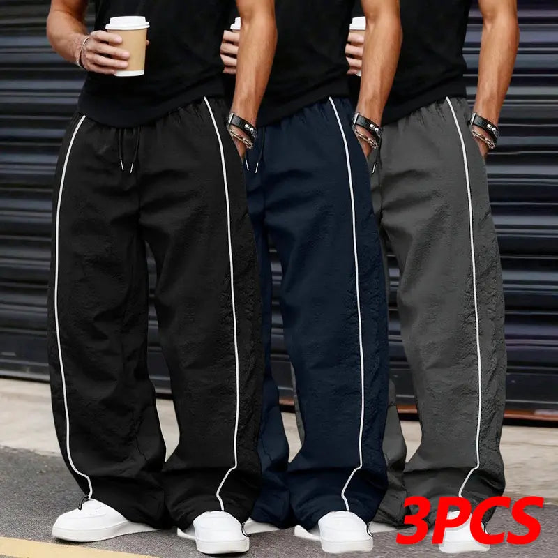 Men’s summer black-and-red quick-dry wide-leg pants with side stripes and a drawstring waist; breathable fabric with a slight wrinkle texture, loose straight cut, side stripe detailing, adjustable cuffs at the leg openings. Suitable for jogging, fitness,